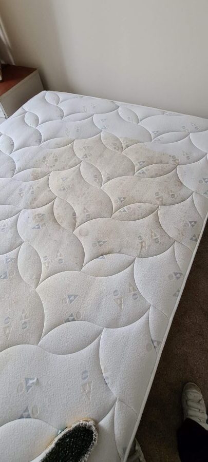 Protein stain on mattress fabric before professional steam extraction cleaning by Ely Cleaning Services in Soham.